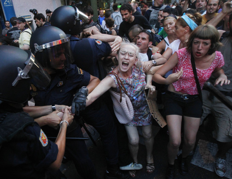A demonstrator is chased by a police officers before been arrested during a protest against the recent austerity measures.