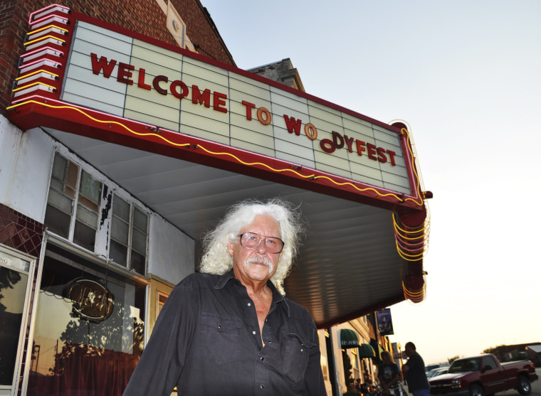 Arlo Guthrie stands outside Okemah's refurbished movie theater that hosts Woodyfest, the annual folk festival that honors his father, Woody Guthrie in Okemah, Okla.