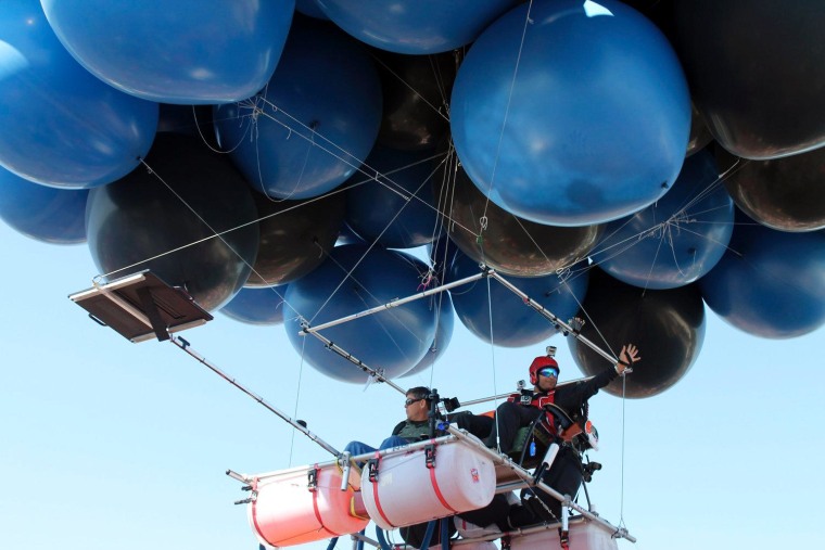 Fareed Lafta and Kent Couch (L) lift off from Couch's Stop & Go Mini Mart in Bend, Oregon, July 14. The two men, sitting in lawn chairs tied to a cluster of 350 helium-filled balloons lift-off in a bid to break the Guinness World Record for the longest two-man cluster balloon flight.