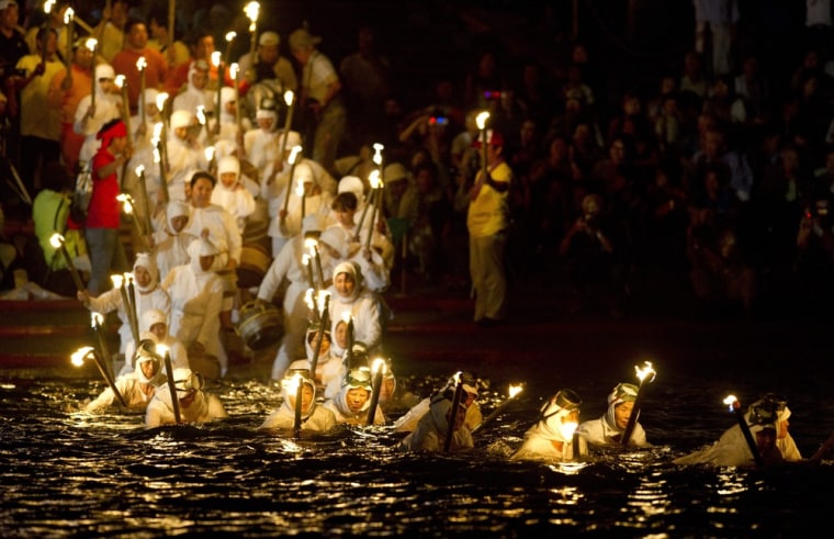 Village women carrying torches enter the sea during the annual Shirahama Ama Women Divers Festival, in Shirahama city, Chiba prefecture, 62 miles (100km) southeast of Tokyo, Japan, July 16. This year, 50 village women dressed as Ama divers performed a ritual swim to pay homage to the ama tradition, while also praying for the safety and success of local fisherman in the coming season. Ama women divers are an ancient tradition in Japan who free dive for shell fish, seaweed and pearls to support their villages.