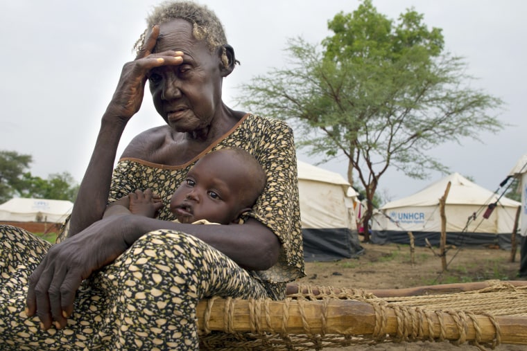 Sinara holds her grandson Karum Bashir while his mother is away getting water on July 16, 2012 in the Jamam refugee camp of South Sudan.