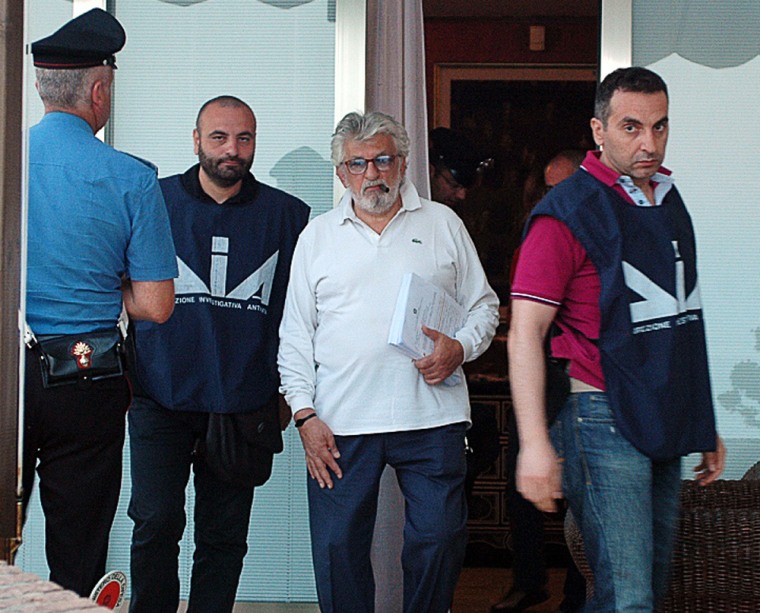 Giuseppe Mandara, center, head of the biggest buffalo mozzarella manufacturing company in Italy, walks alongside policemen from the Anti-Mafia unit of the Italian police, after his arrest near Naples on Tuesday.