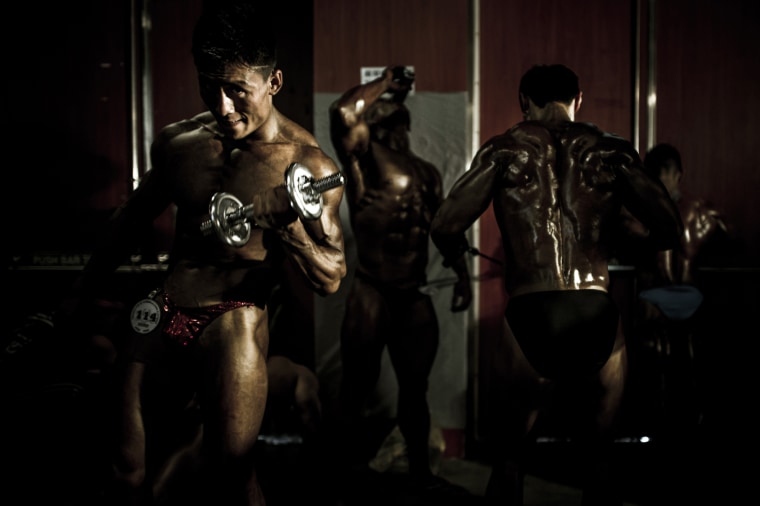 A competitor exercises backstage during the 2012 International Bodybuilding and Fitness Invitation Championship in Hong Kong on July 13.