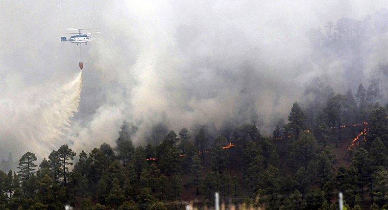A helicopter tries to extinguish a fire in Vinaflor village, southern Tenerife island, the Canary Islands, Spain, on July 17. The forest fire registred late afternoon on July 15 forced the evacuation of four towns and risking a nature reserve.