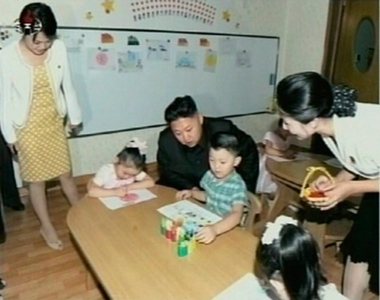 North Korean leader Kim Jong Un visits a pre-school as an unidentified woman stands near him in Pyongyang in this undated image aired that aired on state TV on Sunday.
