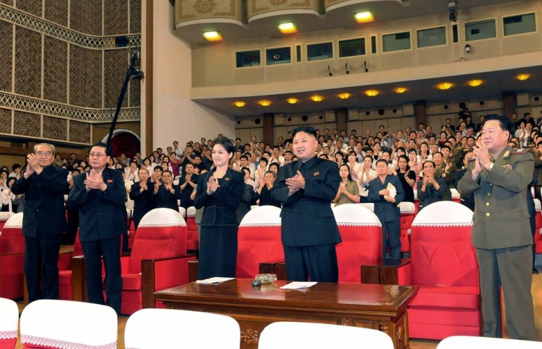 In this photo released by the Korean Central News Agency (KCNA) and distributed in Tokyo by the Korea News Service on July 9, North Korean leader Kim Jong Un, center right, and a woman clap with others as they watch a performance by North Korea's new Moranbong band in Pyongyang, North Korea, Friday, July 6, 2012.