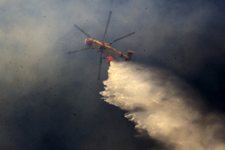 A helicopter fights fire that started close to Bairro da Milharada near Odivelas, Portugal on July 18 2012.