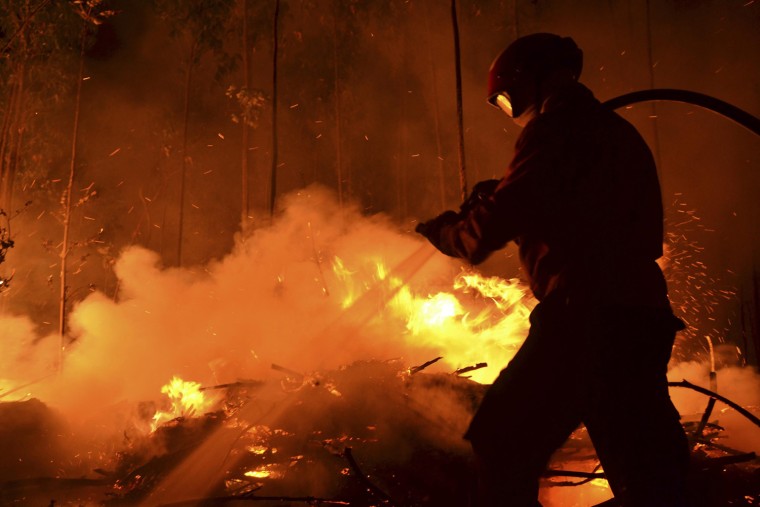 A fireman fights fire that started at Moleanos near the city of Alcobaca, Portugal, on July 18, 2012.