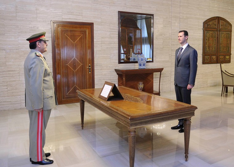 General Fahad Jassim al-Freij, left, is sworn in as Defense Minister by Syrian President Bashar al-Assad in Damascus, Thursday, July 19. Syria's state TV said on Thursday new Defense Minister General al-Freij took his oath of office in front of President al-Assad, who has not appeared in public since a bomb attack killed three of his top security officials.