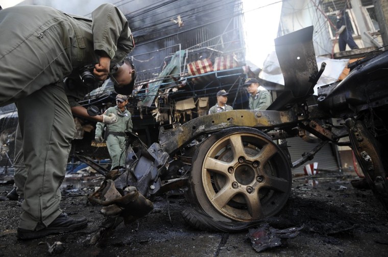 Members of a Thai bomb squad unit inspect the site of a car bomb attack in Narathiwat province on July 20, 2012.