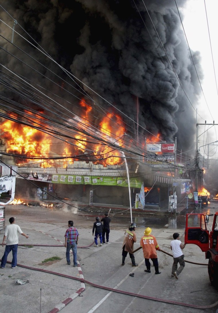 Security forces and firefighters work at the scene of a car bomb attack in Narathiwat province on July 20, 2012.