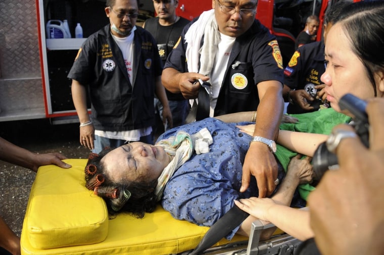 Firemen and rescue workers evacuate a woman on a stretcher after a car bomb blast in Narathiwat province on July 20, 2012.