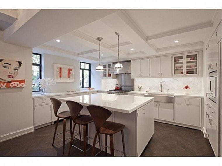High-end appliances and all-white finishes dominate the kitchen.