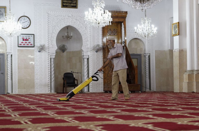 A man vacuums before Friday prayer at the Houda Mosque in Algiers on July 20.