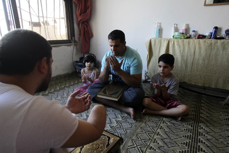 Injured Syrian men, who said their injuries were inflicted by Syrian security forces during the violence in their country, pray at a shelter in Amman, Jordan on July 20.