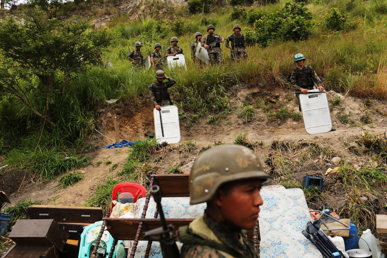 Honduran army personnel watch as residents dismantle their shacks during an eviction on July 20.