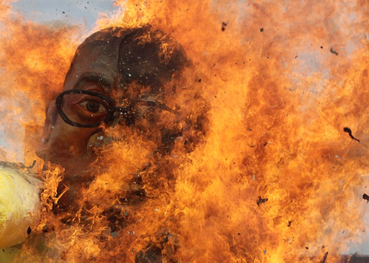 Filipino protesters burn an effigy of Philippine President Benigno Aquino III during a demonstration on a road leading to the Philippine Congress in Quezon City, east of Manila, Philippines, Monday, July 23. President Aquino delivered his State of the Nation Address on Friday, as Filipino activists hold protests demanding government attention to cases of human rights violations, improved agrarian reform, poverty alleviation, job security and the removal of US troops deployed in the Philippines.