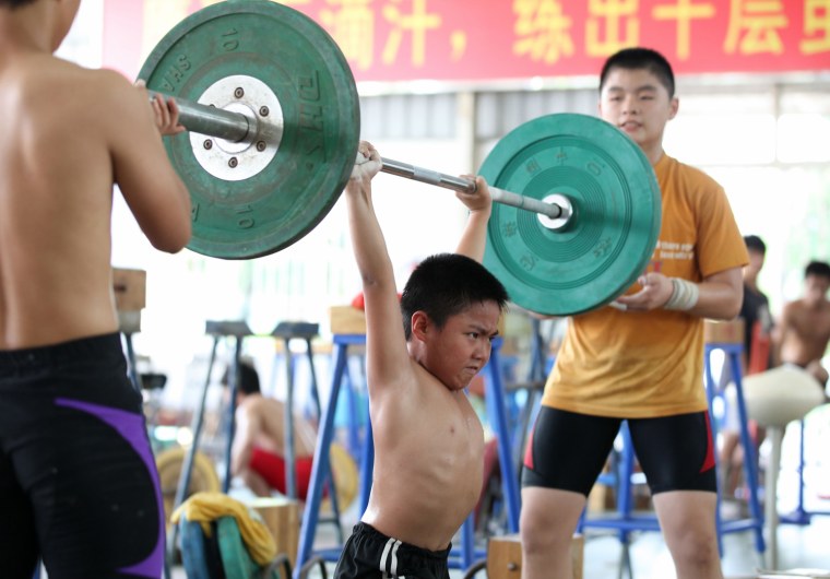 A young Chinese boy training at a weightlifting school in Xiamen, southeast China's Fujian province on July 11, 2012. Dominant China put Asia on top of the world at the Beijing Olympics but the pressure is on as they bid to repeat the feat away from home.
