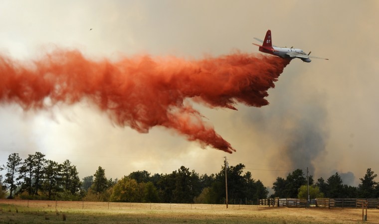 A plane drops fire retardant Monday July 23, at the Fairfield Creek fire near Springview, Neb. The sprawling fire, sparked Friday by lightning, had charred at least 50,000 acres by Monday morning and it wasn't clear how much of the fire had been contained.