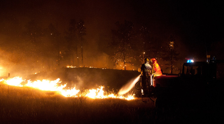 Firefighters work through the night early Tuesday July 24, at the Fairfield Creek fire near Springview, Neb. The sprawling fire, sparked Friday by lightning, had charred at least 50,000 acres by Monday morning and it wasn't clear how much of the fire had been contained.