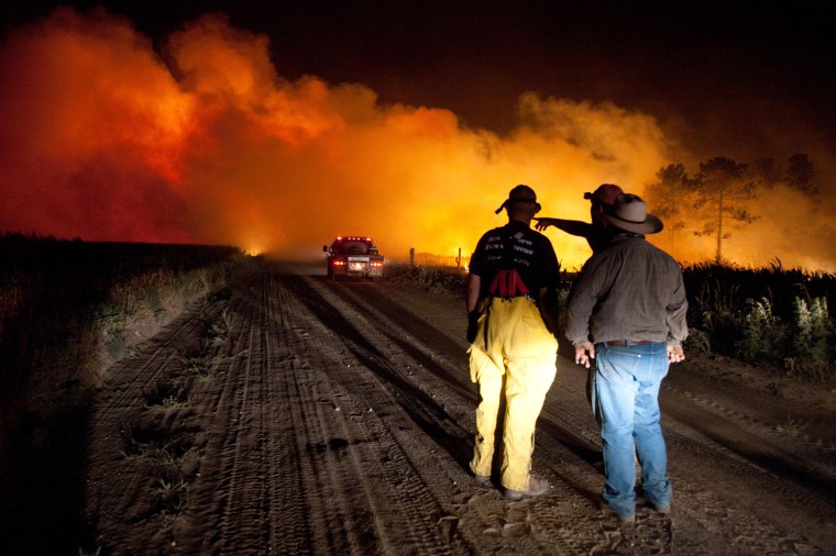 Firefighters plan an attack early Tuesday July 24, at the Fairfield Creek fire near Springview, Neb. The sprawling fire, sparked Friday by lightning, had charred at least 50,000 acres by Monday morning and it wasn't clear how much of the fire had been contained.