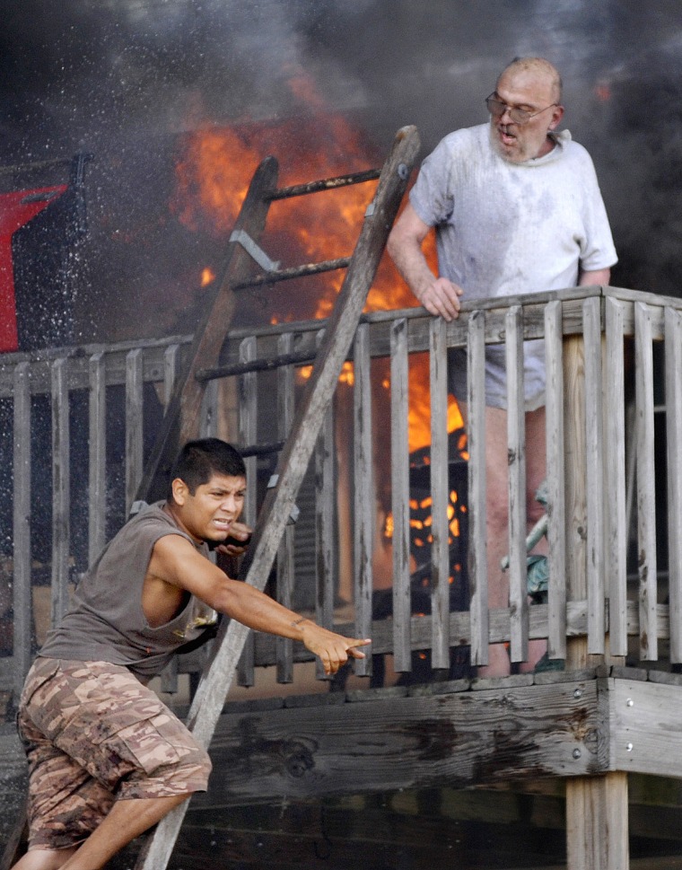 Edwardo Martinez yells for help as he tries to rescue Pete Lui off the balcony of Lui's home in Racine, Wis.