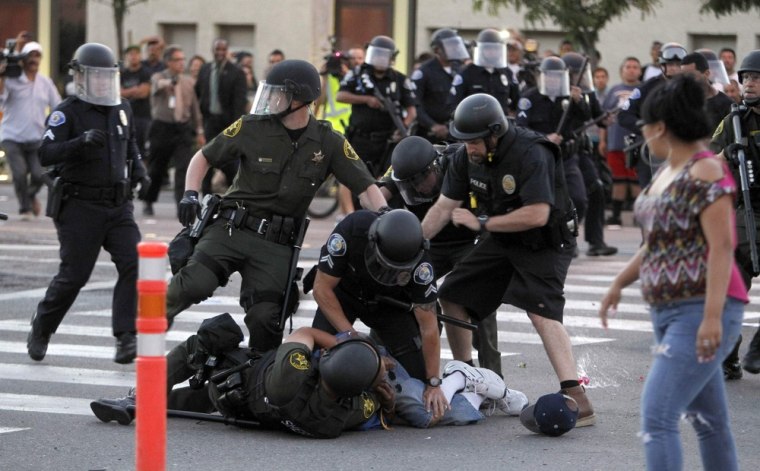 A protester is arrested by police officers from Orange County as protesters try to occupy the the intersection of Anaheim Blvd. and Broadway on July 24, 2012.