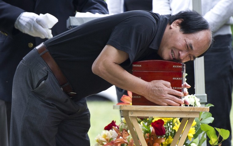 Daran Lin hugs the urn bearing the remains of his son, Jun Lin, during funeral services Thursday, July 26 in Montreal. Lin's dismembered torso was found on May 29 stuffed in a suitcase outside an apartment building, while other body parts were mailed to Ottawa and Vancouver. Luka Rocco Magnotta has pleaded not guilty to several charges in connection with Lin's death, including a count of first-degree murder.