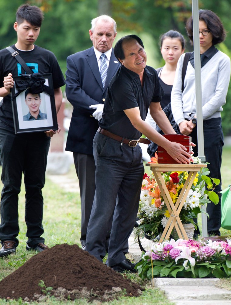 Daran Lin touches the urn bearing the remains of his son, Jun Lin, during funeral services Thursday, July 26 in Montreal.