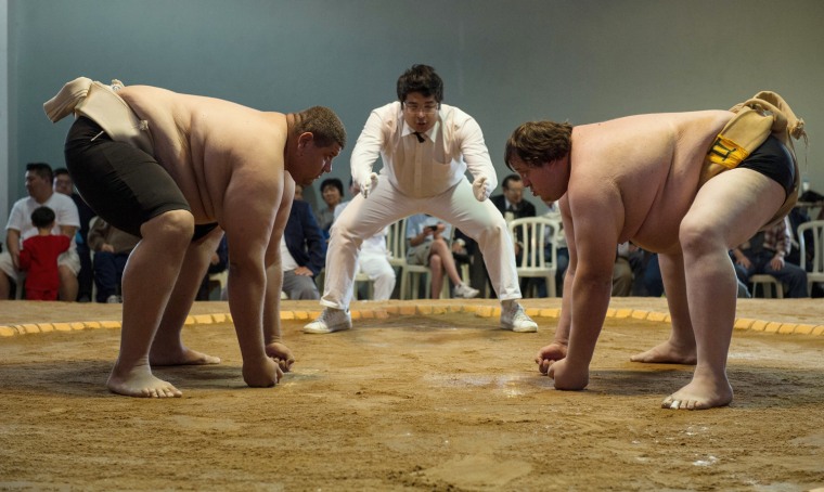 Juan Castro, left, a heavy weight champion from Venezuela, and Mario Frabetti, an open champion from Brazil, face each other before a match during the Sumo wrestling South American Championship in Sao Paulo, Brazil on July 22, 2012.