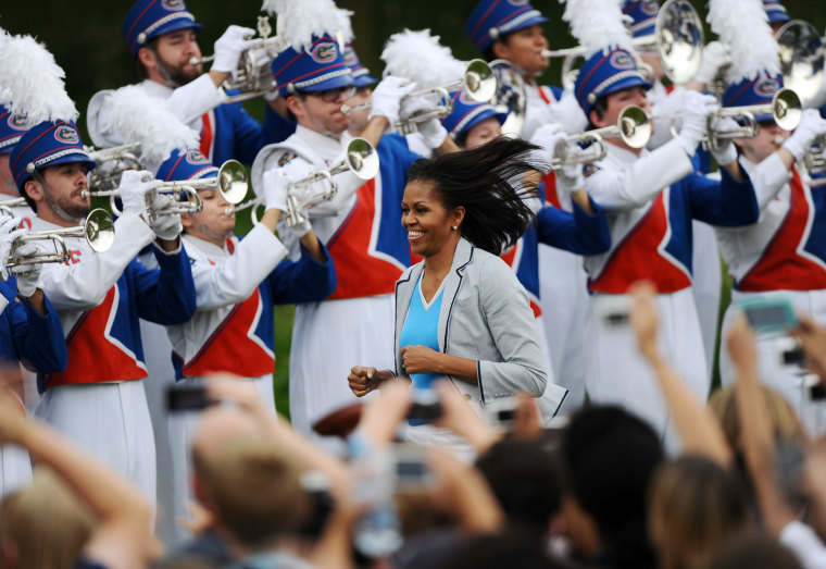 US First Lady Michelle Obama jogs to the stage to speak during