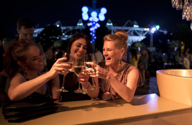 Anna Celeste Walters, left, has a toast with her friends Amy Loudon, center, and Alex Sinclair. They were three of about a thousand people who celebrated the opening ceremonies at Forman's Smokehouse, a family-run fish processing company in East London.