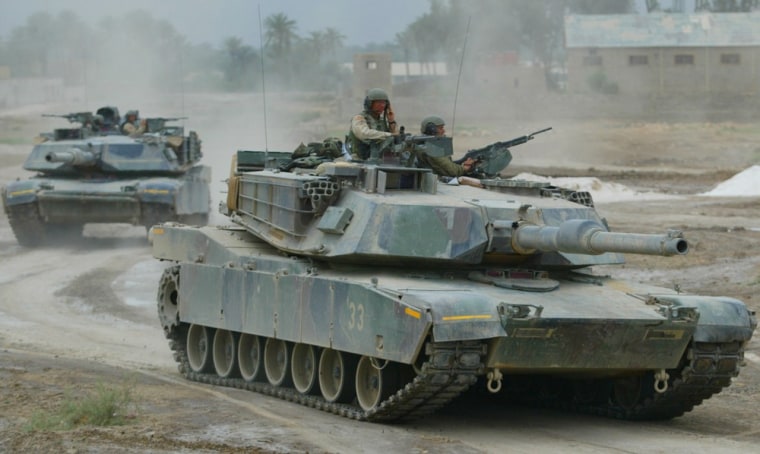 U.S. M1 Abrams tanks withdraw to a safe position after mortar rounds landed nearby in Kufa, Iraq, on April 29, 2004.