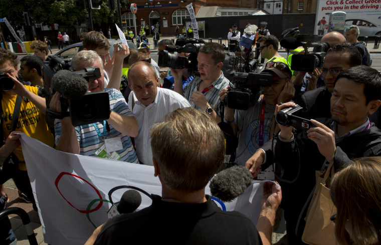 A crush of media surrounds a supporter of the Olympics during an anti-Olympic protest march Saturday in east London.