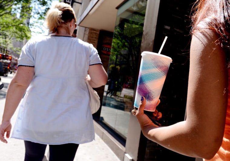 A woman holds a large soda on a street in New York City. Mayor Michael Bloomberg announced plans to implement a ban on the sale of large sodas and other sugary drinks at restaurants, movie theaters and street carts. The law is another effort by the administration to fight obesity.