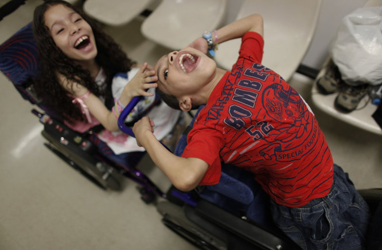 Samille, left, and Dhones Amor Divino, joke in their wheelchairs as they wait with their sister Izabely for the start of a session of physical therapy in the AACD clinic in Sao Paulo March 23. All three children suffer from a disease called Pelizaeus-Merzbacher, a rare genetic nervous disorder which affects coordination and intellect.
