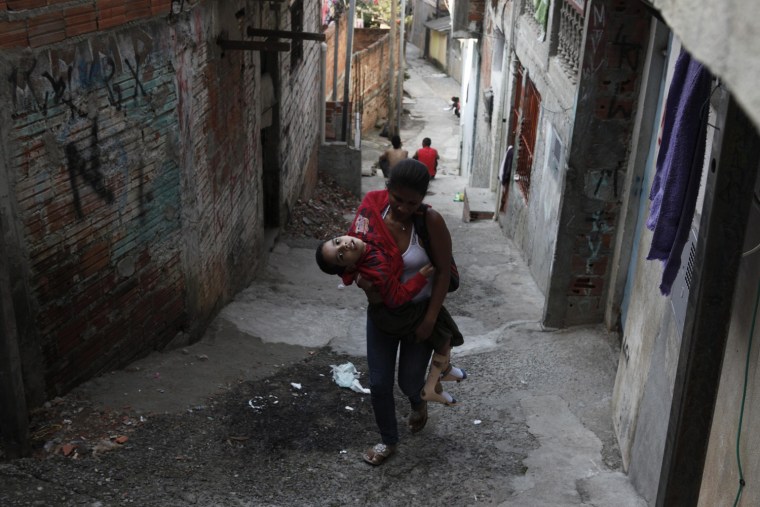 Rose Amor Divino carries her son Dhones home from school in the Brasilandia favela of Sao Paulo, April 24. Dhones and his two sisters suffer from a disease called Pelizaeus-Merzbacher, a rare genetic nervous disorder which affects coordination and intellect. Brazil's social security system INSS granted the family monetary assistance only for one of the three children, leaving the others to depend on the income from their father's job in a bakery.