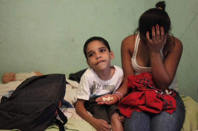 Rose Amor Divino gives medicine to her son Dhones at home in the Brasilandia favela of Sao Paulo, April 24.