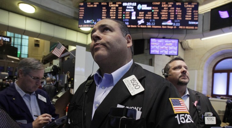 Anthony Riccio, center, work with fellow traders on the floor on Friday. The Dow Jones industrial average dropped more than 200 points, erasing what was left of its gain for the year.
