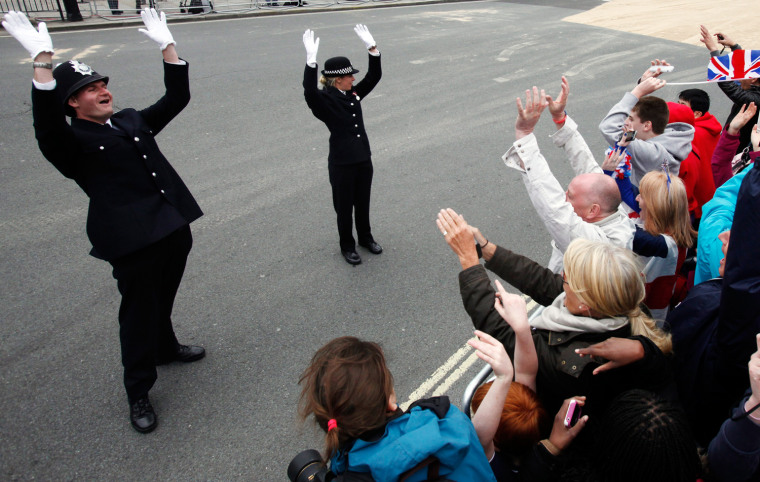 Metropolitan police officers encourage Royal supporters to cheer before Britain's Queen Elizabeth II Carriage Procession from Westminster Hall to Buckingham Palace in London, Britain, on June 5. The British Royal Family's procession followed a national service of thanksgiving at St Paul's Cathedral, a reception at Guildhall and a lunch at Westminster Hall. This is the final day of the Diamond Jubilee weekend celebrating Queen Elizabeth II's 60 years on the throne.