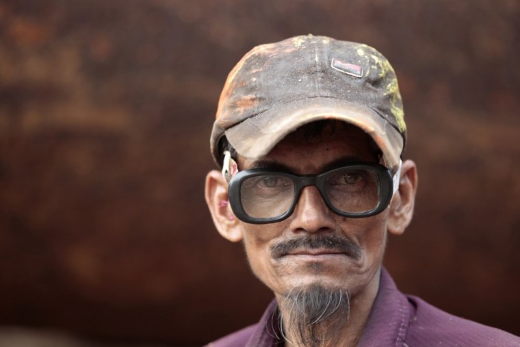 A worker is seen in a shipyard by the river Buriganga.