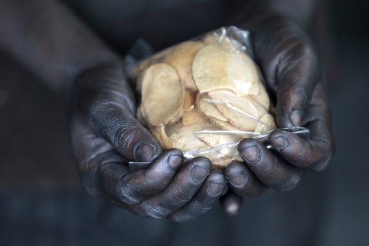 A worker holds food during a break at a shipyard by the river Buriganga.