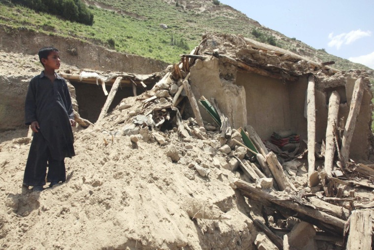 A boy stands by the ruins of a home after Monday's earthquake in Baghlan, north of Kabul, Afghanistan on June 12, 2012.