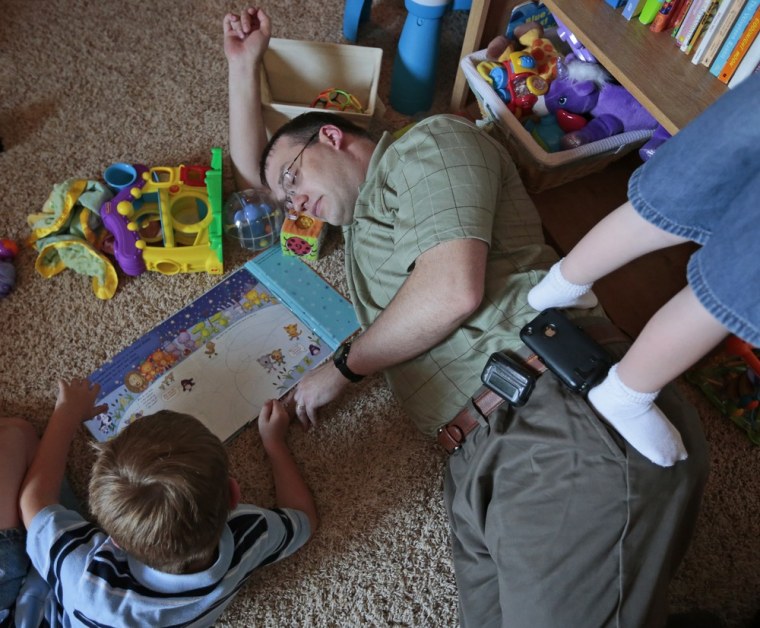 Dustin Baylor closes his eyes while playing with his sons Paxton, 6, left, and Garrison, 4, after work at their home Friday, June 8, 2012 in Enid, Okla.