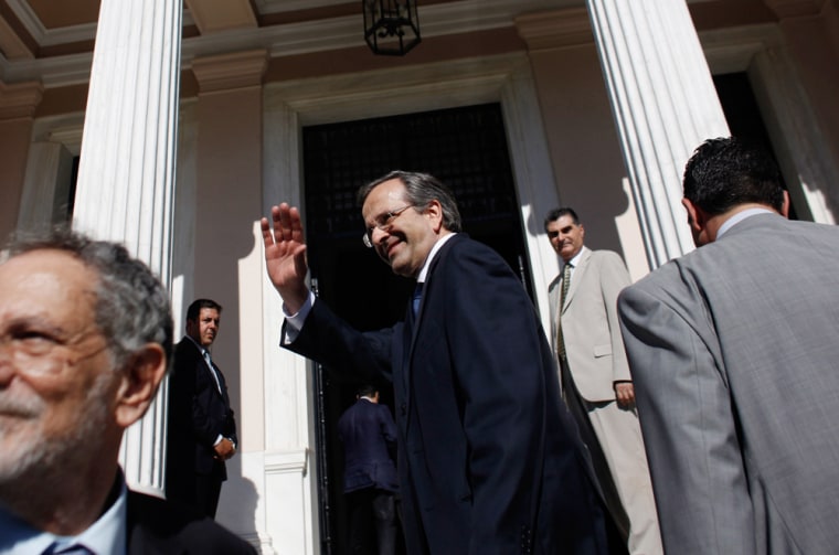Greece's newly sworn-in Prime Minister Antonis Samaras gestures to supporters after taking over from caretaker Prime Minister Panayiotis Pikramenos at Maximos Mansion in Athens.