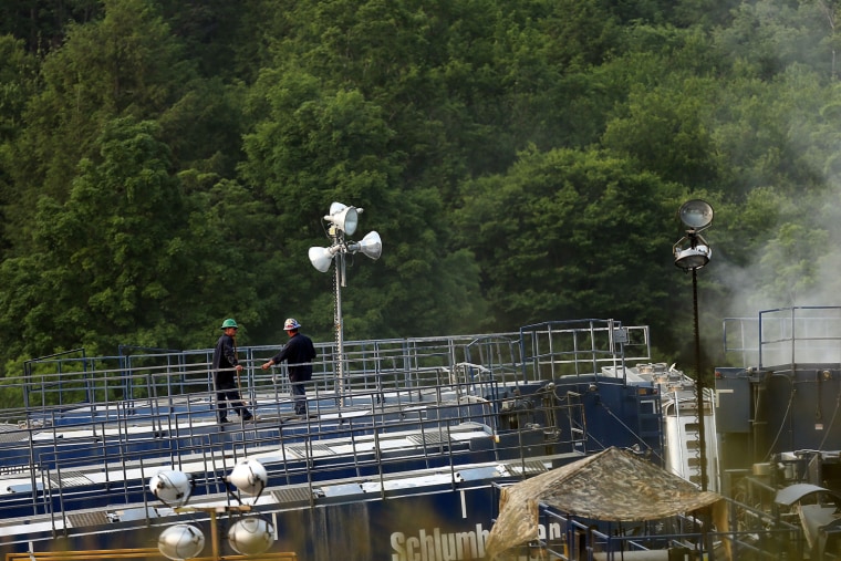 Workers tend to a natural gas valve at a hydraulic fracturing site in South Montrose, Pennsylvania. Hydraulic fracturing, also known as fracking, stimulates gas production by injecting wells with high volumes of chemical-laced water in order to free-up pockets of natural gas below.