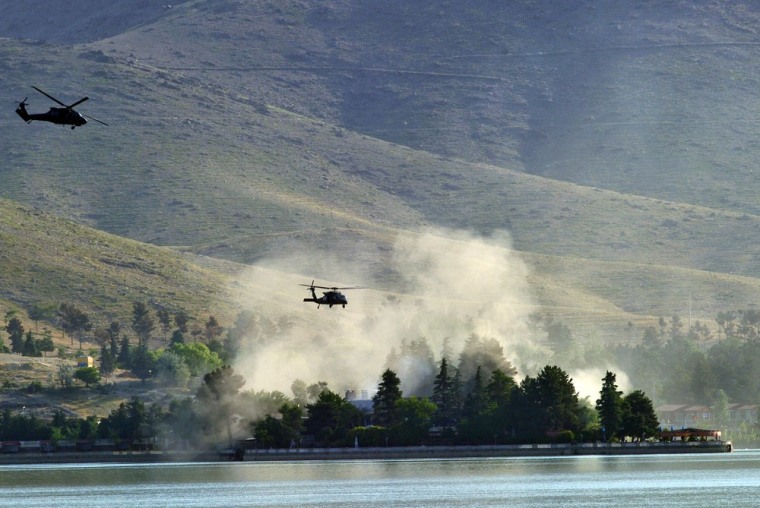 NATO UH-60 Black Hawk helicopters fly near the Spozhmai Hotel in Qargha lake in the outskirts of Kabul in the early hours of Friday.