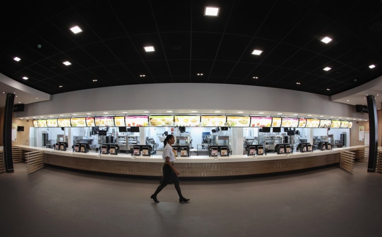 Assistant manager Rachel Lucien walks past the checkouts in the world's largest McDonald's restaurant which is their flagship outlet in the Olympic Park on June 25 in London.