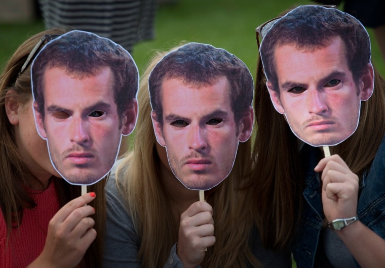Tennis fans pose for pictures with Andy Murray masks as they queue for tickets.