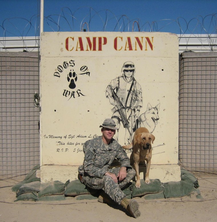 Black and Diego, in November 2006, sit in front of a memorial for a former handler and his dog, both of whom were killed in action.